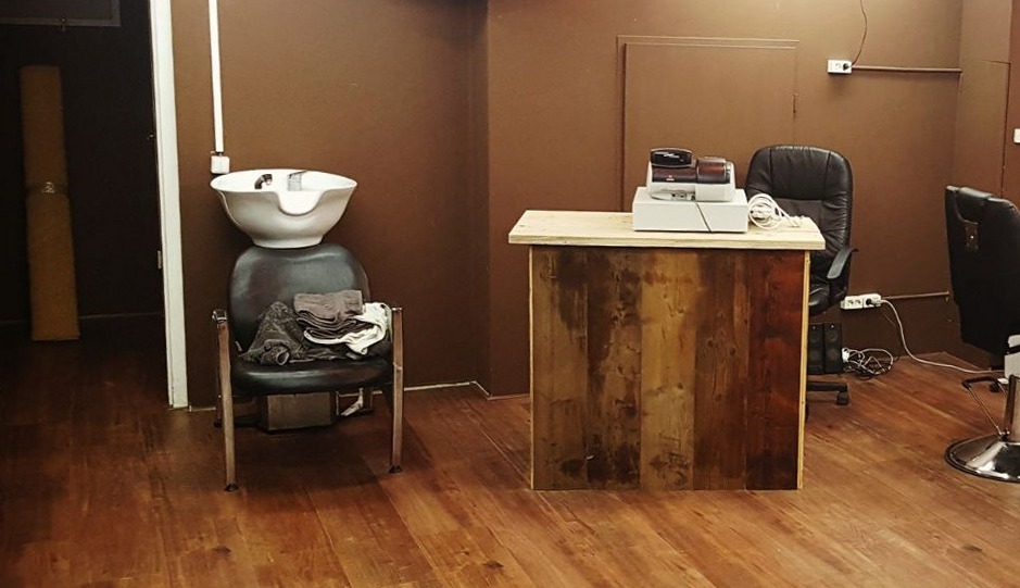 Wasbak, een toonbank van oud hout en een kappersstoel in de zaak van Star Barber
