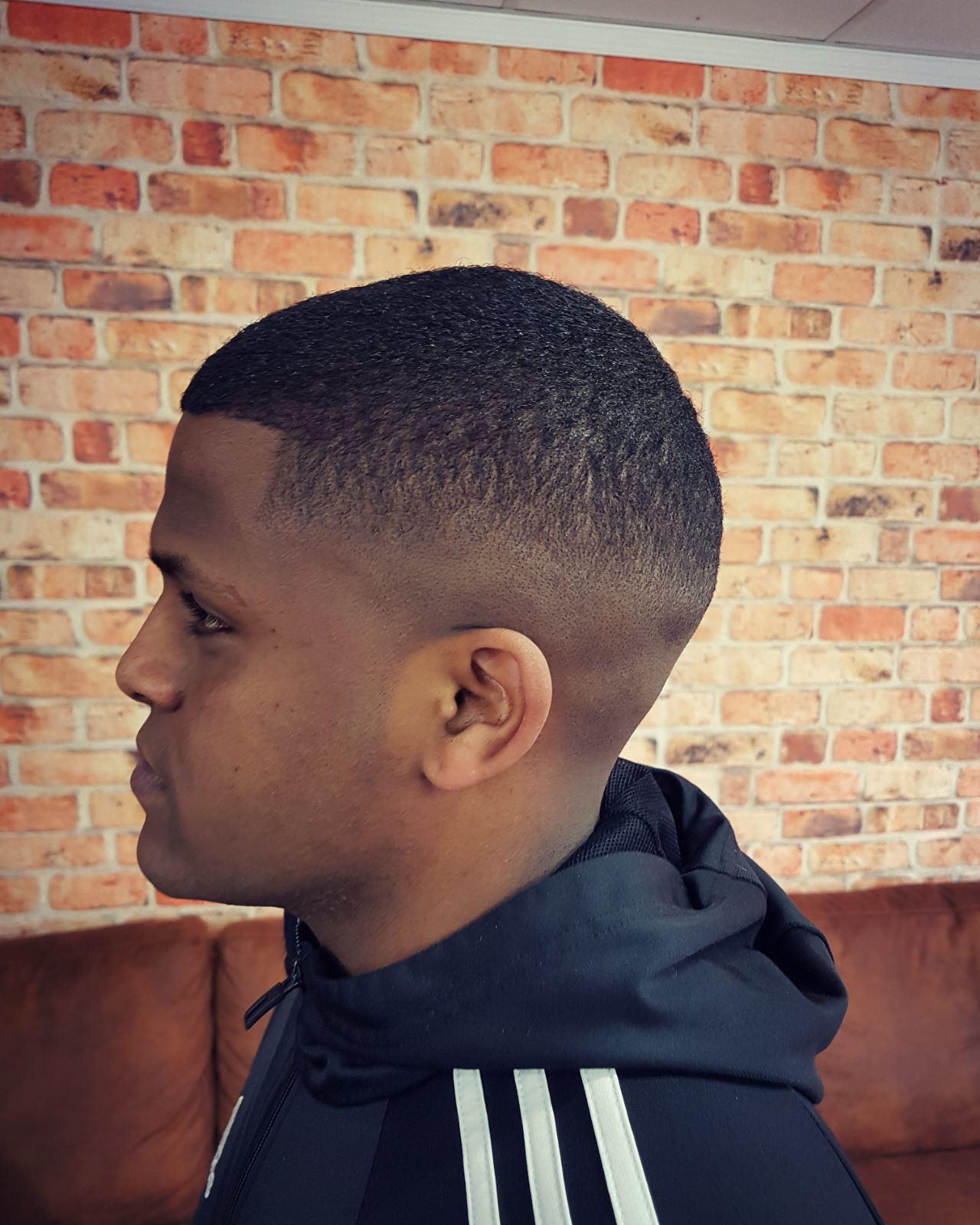 Zijaanzicht van een skin fade voor een bakstenen muur