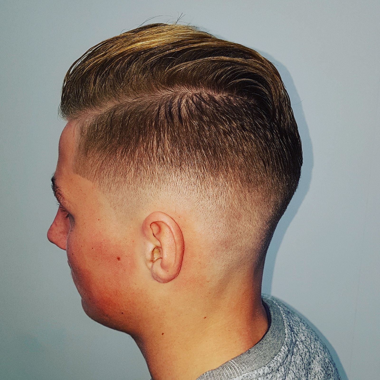 Zijaanzicht van een fade met het haar bovenop naar achteren gestyled